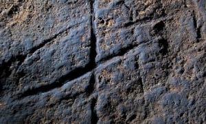 Deep graven lines enhanced with colored clay decorate a Neanderthal cave.  Is this the work of a prehistoric Miro?